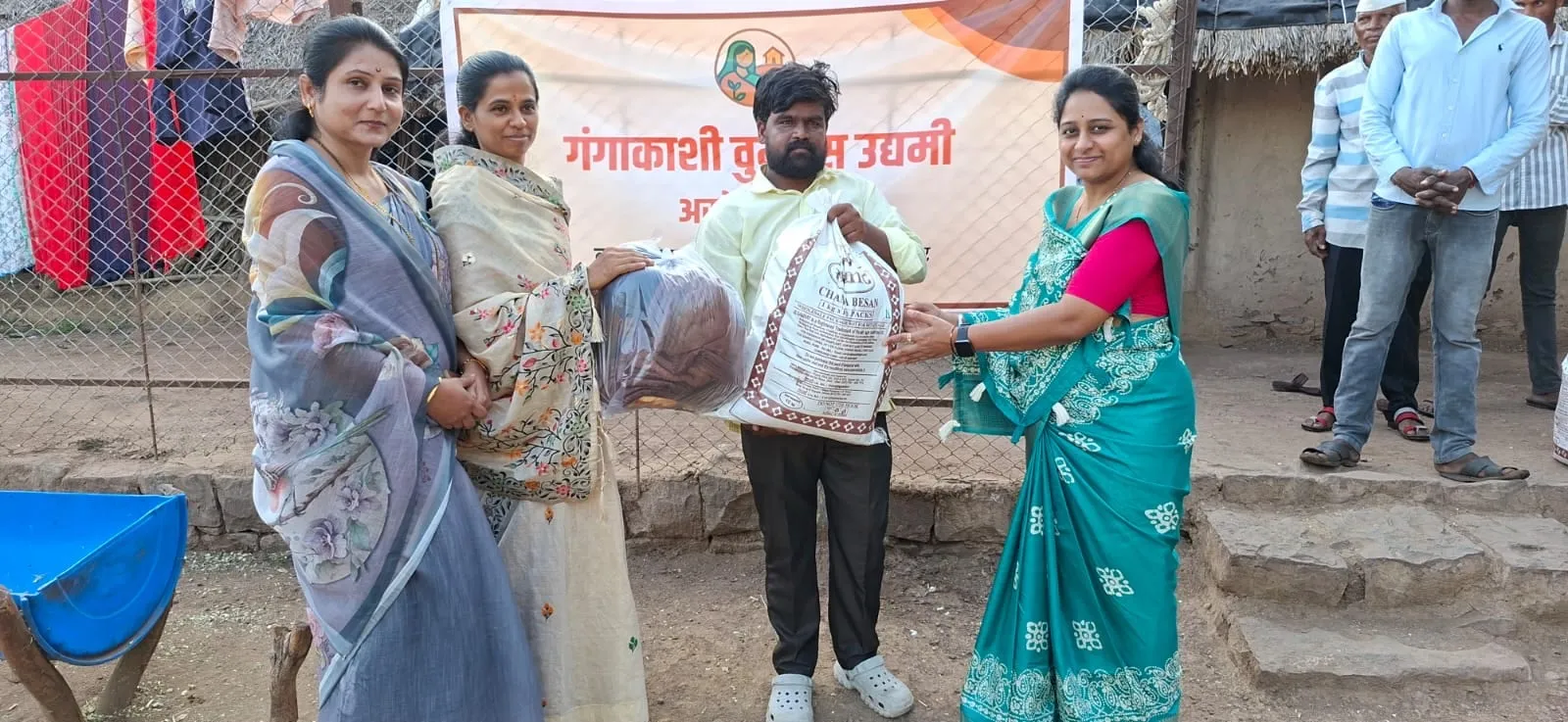 A GK Udyami member handing over a grocery kit to a family in Baragaon Nandur